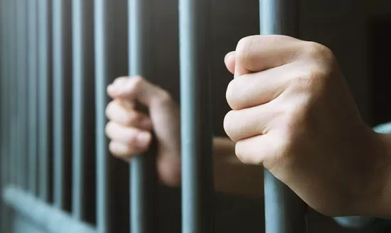 celda manos hombre rejas