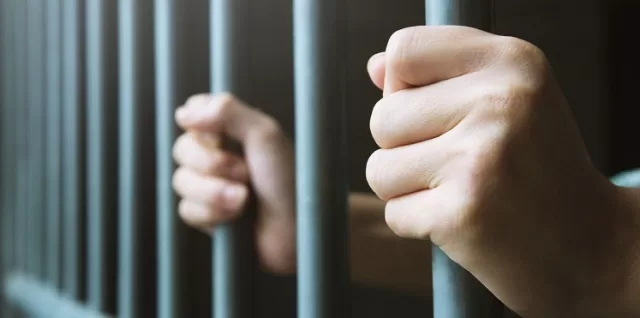 celda manos hombre rejas